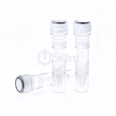 Three clear glass vials with ridged screw caps stand upright on a white surface, foreground showing a fourth vial lying on its side periphery of the image.