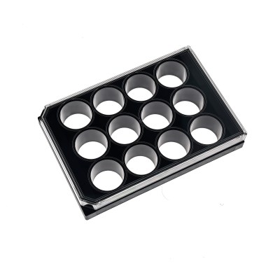 Angle view of a black plastic egg tray with circular cavities for eggs against a white background.