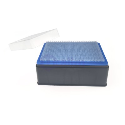 Lab rack holding small clear tip tubes on a blue tray with a white lid leaning against it.