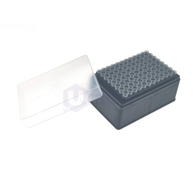 Close-up of a dark gray rectangular device with a textured grid of round pegs and a translucent white cover.